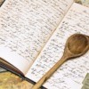 A recipe book with a wooden spoon.
