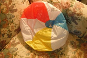 A deflated beach ball used as a wedge pillow.