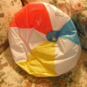 A deflated beach ball used as a wedge pillow.