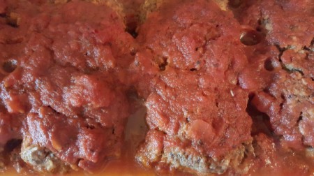 A tomato sauce covering the meatloaves.