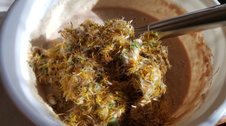 Mixing the blossoms into the batter.
