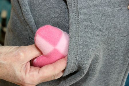 pink heart shaped hand warmer going into pocket