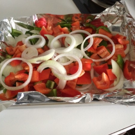 Onions and peppers on aluminum foil.