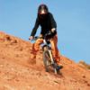 person mountain biking on red loam hill