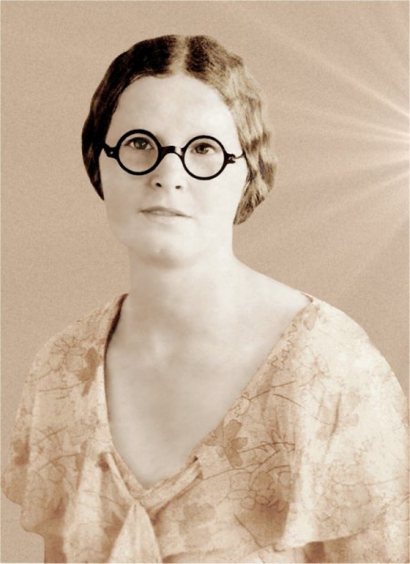 An old fashioned black and white photo of a woman in glasses.