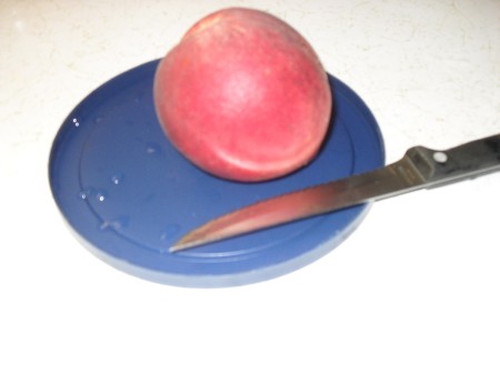 can lid with a peach and knife