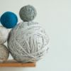 large ball of yarn with smaller ones stacked against it