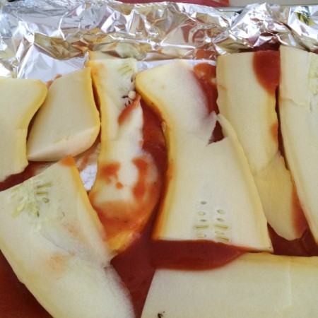 zucchini on sauce in baking pan