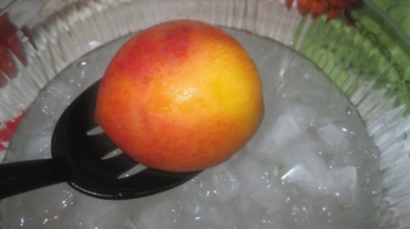 peach in slotted spoon