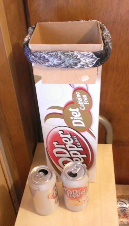 A long soda box with the flaps tied back.