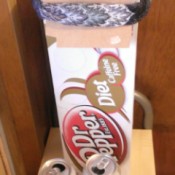 A long soda box with the flaps tied back.