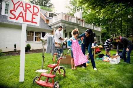 An active yard sale in the front yard of a house.