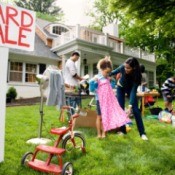 An active yard sale in the front yard of a house.