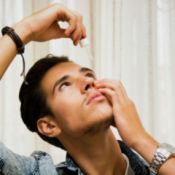 man using eye drops