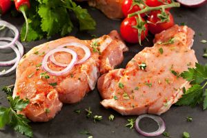 raw pork steaks with tomatoes and onions