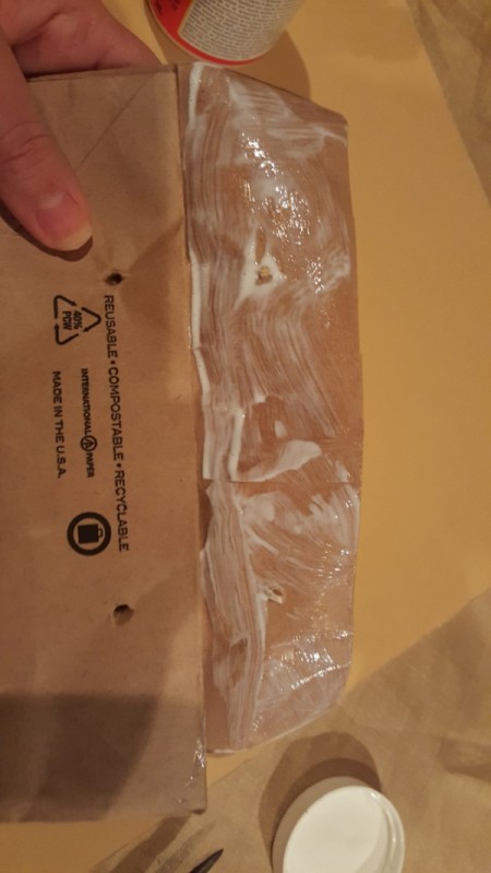 Glueing the paper bag to seal it.