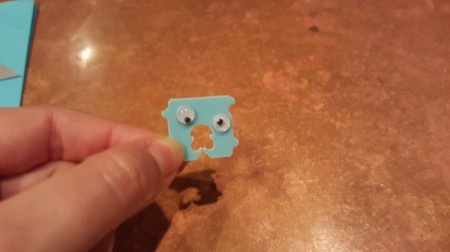 A googly eye monster made from a bread tie.