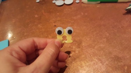 A googly eye monster made from a bread tie.