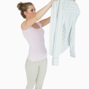 A woman inspecting a snagged shirt.
