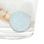 A denture tablet submerged in water.