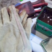 gardening gloves and open can of bag balm
