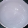 A white bowl with scratches removed on one side.