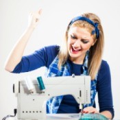 Photo of a woman with a broken sewing machine that won't go in reverse.