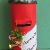 A paper tube Santa mailbox, colored red.