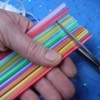Cutting straws to make small sections for the necklace.