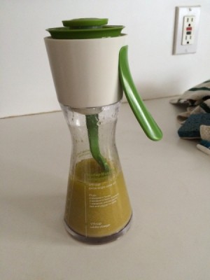 A container filled with homemade vinaigrette.