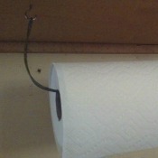 A paper towel holder made from a clothes hangar.