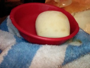 A dinner roll in a red bowl.