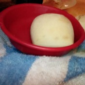 A dinner roll in a red bowl.
