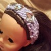A crocheted headband on an American girl doll.