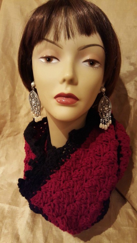 A burgundy and black scarf displayed on a mannequin head.