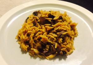 A plate of orzo risotto with mushrooms and cheese.