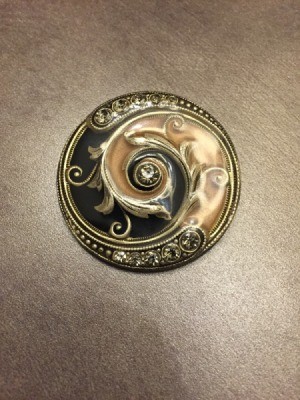 A circular vintage brooch.