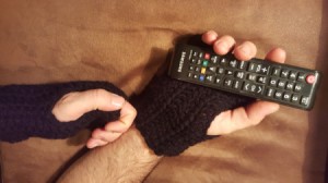 Crochet Men's Fingerless Gloves - person wearing gloves using a remote