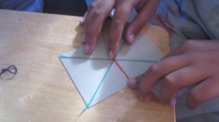 beginning to create painting by sticking floss to back of tile