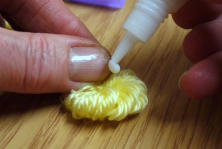 Yarn Flower Hair Clip put a drop of PVA glue in center of flattened flower to secure cut yarn ends