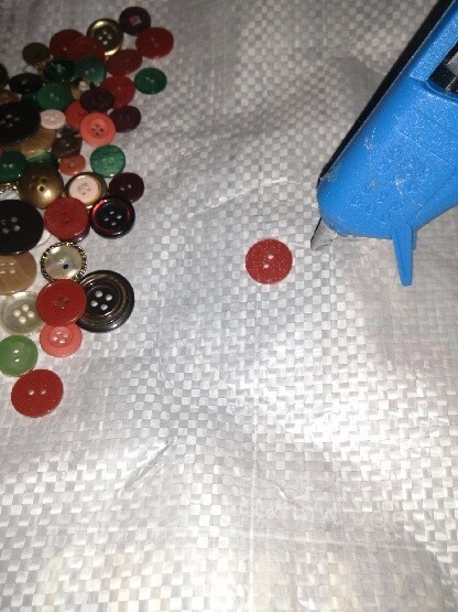 collection of buttons and glue gun used to make the pattern on the dog food bag tote bag