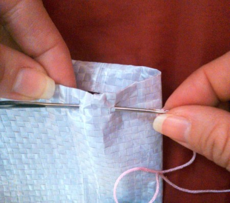 stitching through both layers of the bag to finish the top edge of tote