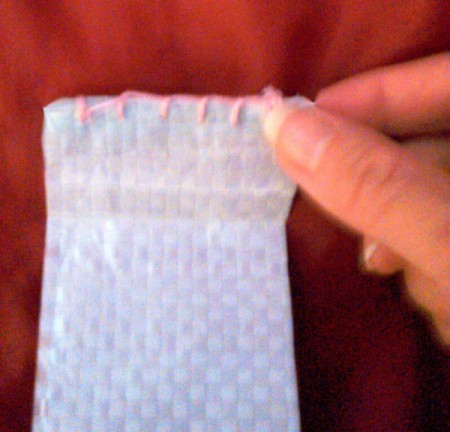 turn under edge of strip used to make the handles before stitching to the tote bag