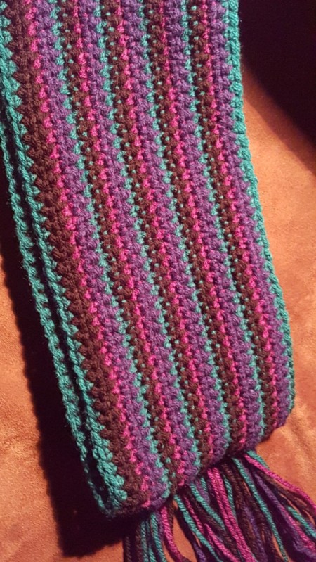 peacock striped scarf lying on flat surface