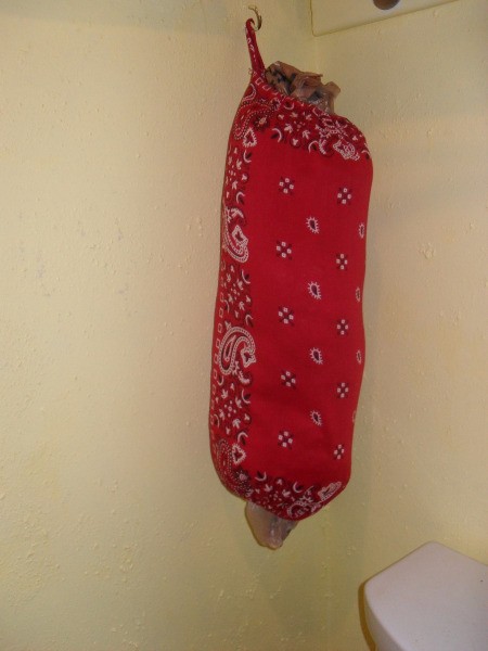 A storage tube for plastic bags made from bandanas.