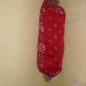 A storage tube for plastic bags made from bandanas.