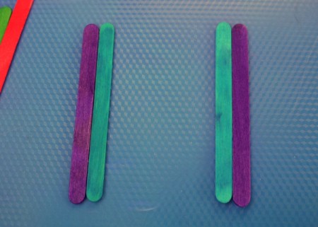 laying out two sets of one blue and one purple stick