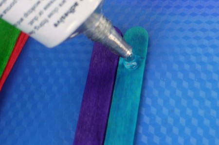adding glue to the blue stick
