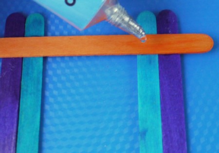 putting glue on the orange stick prior to adding the green sticks