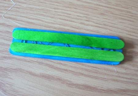 glue down two green sticks with a space wide enough to put a stick on end between them